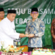 Foto : Wabup HSS, Syamsuri Arsyad menerima potongan nasi tumpeng dari Kepala Sekolah MAN 2 HSS, Muhammad Amin.