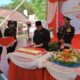 Bupati HSS, Achmad Fikry melakukan pemotongan kue yang akan diberikan kepada Kapolres HSS, AKBP Leo Martin Pasaribu dalam acara syukuran HUT ke 77 Bhayangkara