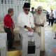 Pj Bupati HSS, Hermansyah beserta istri memasukan surat suara kedalam kotak suara setelah melakukan pencoblosan.