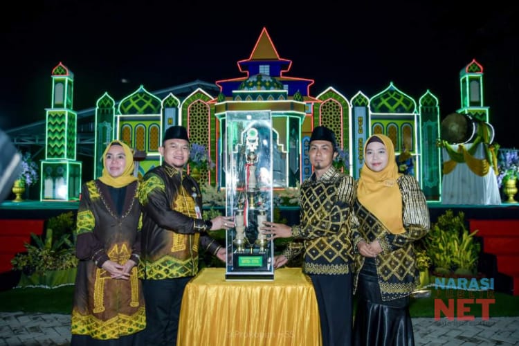 Pj Bupati HSS, Hermansyah menyerahkan piala juara umum kepada Camat Simpur, Nafarin.
