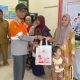 CSR Section Head PT AGM, Widharto Ali secara simbolis menyerahkan bantuan kesehatan berupa Pemberian Makanan Tambahan (PTM) untuk balita kepada penerima manfaat. (Foto : Istimewa)