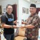 Pj Bupati HSS, Endri menerima sebuah buku dari Bupati HSS Periode 2013-2023, Achmad Fikry. (Foto : Prokopim HSS)