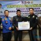 Bupati HSS, Syafrudin Noor menyerahkan bantuan dana hibah secara simbolis kepada ketua Kerukunan BPK HSS, Ronaldy Prana Putra. (Foto : Prokopim HSS)