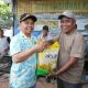 Bupati Tapin H. Yamani menyerahkan bantuan beras gratis kepada salah satu penerima manfaat pada kegiatan Jumat Berkah. (Foto : Prokopim Tapin)