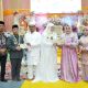 Bupati Tapin H Yamani dan Ketua TP PKK Tapin Hj Faridah didampingi Wabup H Juanda beserta istri menyerahkan dokumen buku nikah secara simbolis. (Foto : Prokopim Tapin)