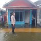 Anggota Polsek Danau Panggang melakukan monitoring terhadap debit air di pemukiman warga. (Dok. Humas Polres HSU)