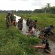 Babinsa dan petani di HSS gotong royong bersihkan saluran irigasi. (Dok. Pendim HSS)
