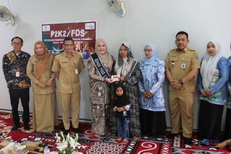 Bunda PAUD HSS, Hj Mustaidah menyerahkan secara simbolis bantuan PKH kepada salah satu keluarga penerima manfaat. (Dok: Istimewa)