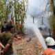 Personel TRC BPBD Tapin melakukan pembasahan terhadap api yang menghanguskan sebuah rumah di Desa Desa Kepayang, Kecamatan Tapin Tengah. (Dok: Istimewa)