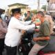Bupati Kapuas, HM Wiyatno memasangkan masker kepada salah seorang pengguna jalan. (Dok: Istimewa)
