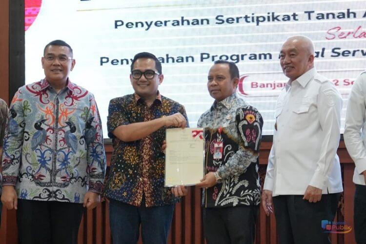 Bupati Tapin H Yamani menerima sertifikat hak pakai atas tanah aset daerah dari Ketua Komisi II DPR RI Rifqinizami Karsayuda. (Dok: Prokopim Tapin)