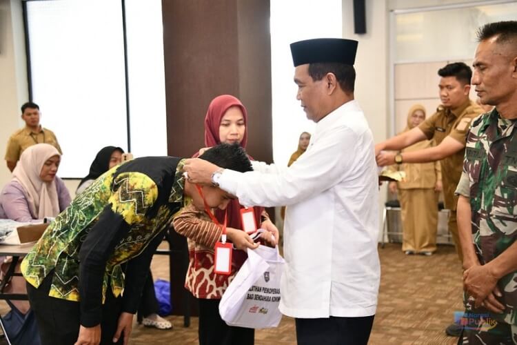 Bupati HSS menyematkan tanda peserta pelatihan Perkoperasian bagi Bendahara KDMP. (Dok: Istimewa)