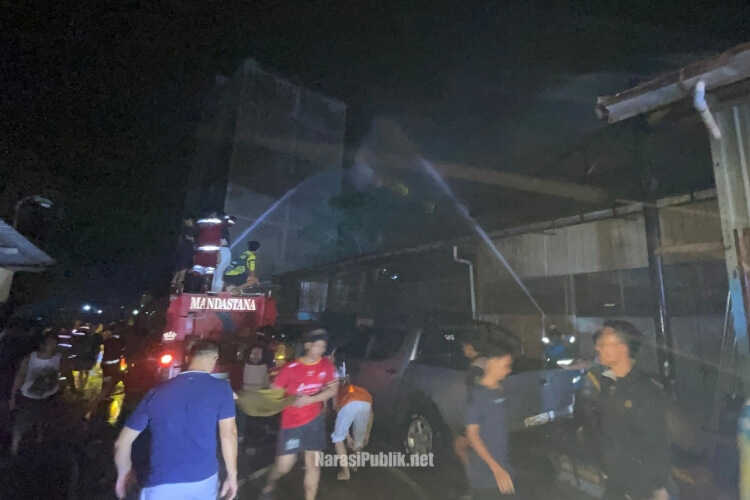 Anggota pemadam kebakaran gabungan melakukan pembasahan terhadap kobaran api yang muncul di area gudang agen LPG Desa Rantau Bujur, Kecamatan Banjang, Kabupaten HSU. (Dok: Narasi Publik)