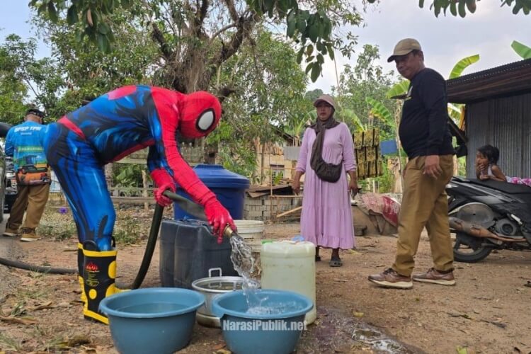 Kadis Pertanian dan Ketahanan Pangan Kalsel menyalurkan air bersih di Desa Palam menggunakan kostum Spiderman. (Dok: MC Kalsel)
