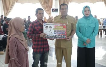 Bupati HSS, Syafrudin Noor didampingi Ketua TP PKK HSS Mustaidah menyerahkan secara simbolis bantuan PRS kepada perwakilan pemerintah manfaat. (Dok: Prokopim HSS)
