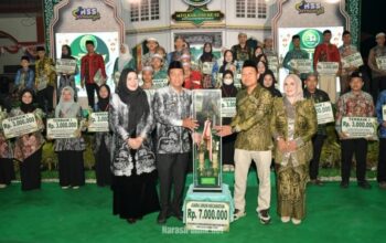 Bupati HSS Syafrudin Noor didampingi Ketua TP PKK HSS Mustaidah menyerahkan secara simbolis trophy juara umum MTQ Nasional ke-52 Tingkat Kabupaten HSS Tahun 2026. (Dok: Istimewa)
