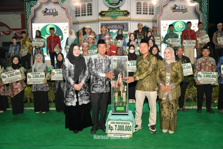 Bupati HSS Syafrudin Noor didampingi Ketua TP PKK HSS Mustaidah menyerahkan secara simbolis trophy juara umum MTQ Nasional ke-52 Tingkat Kabupaten HSS Tahun 2026. (Dok: Istimewa)