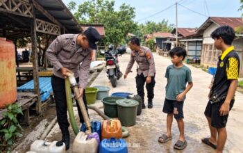 Anggota Polsek Banua Lawas, Polres Tabalong menyalurlan air bersih kepada warga Desa Talan yang mengalami dampak kekeringan. (Dok: Polres Tabalong)