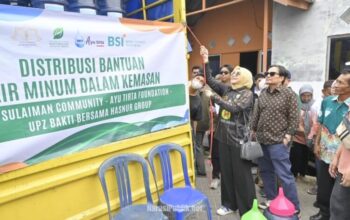 Hasnuryadi Sulaiman bersama istri drg Ellyana Trisya menyalurkan bantuan air mineral galon dari Komunitas NSC Peduli untuk warga Desa Simpang Empat, Kabupaten Banjar. (Dok : Narasi Publik)