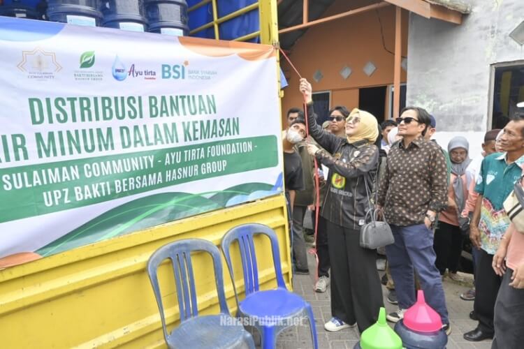 Hasnuryadi Sulaiman bersama istri drg Ellyana Trisya menyalurkan bantuan air mineral galon dari Komunitas NSC Peduli untuk warga Desa Simpang Empat, Kabupaten Banjar. (Dok : Narasi Publik)