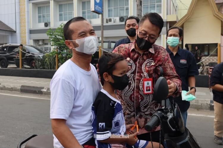 Sekda HSU Adi Lesmana didampingi Ketua PWI HSU M Akbar membagikan masker gratis kepada pengguna jalan. (Dok: Narasi Publik)