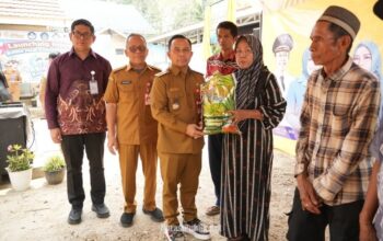 Bupati Tapin, H. Yamani menyerahkan secara simbolis bantuan paket sembako dari Dinas Sosial kepada warga Desa Hatiwin. (Dok: Prokopim Tapin)